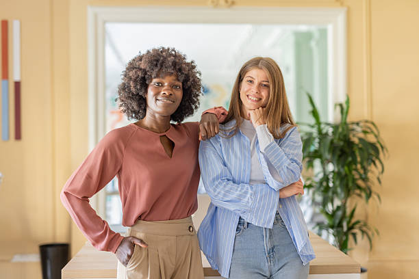 istock Two close women enjoying a moment in a modern office. 2244065990