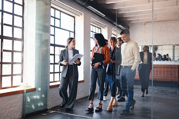 istock Group Of Professional Coworkers Walking Through Modern Office Corridor For Teamwork And Collaboration 2244066196