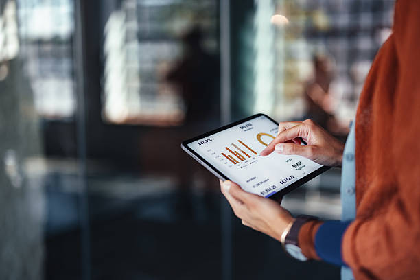 istock Professional Reads Financial Trends On Tablet With Charts In Modern Office Setting 2244066229