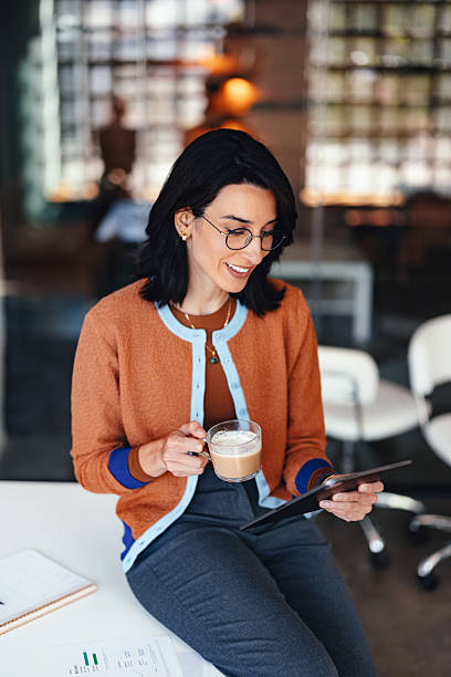 istock Confident Woman Working on Tablet with Coffee in a Modern Office Setting 2244066232