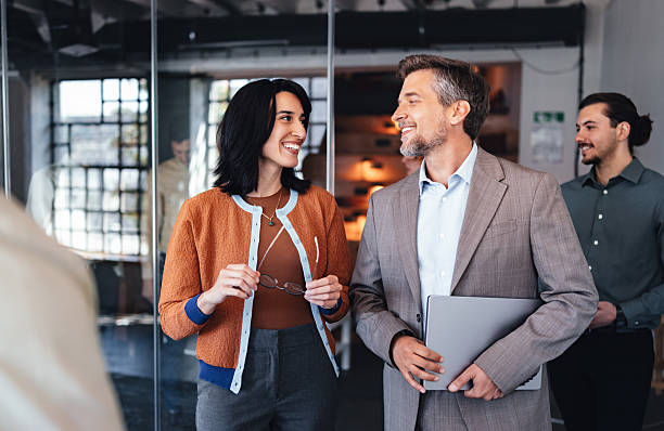 istock Professional Colleagues Chatting In Modern Office Corridor With Laptop And Glasses 2244066233