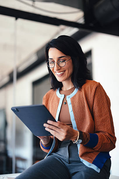 istock Casual Business Professional Woman Smiling While Using Tablet in Modern Office 2244066240