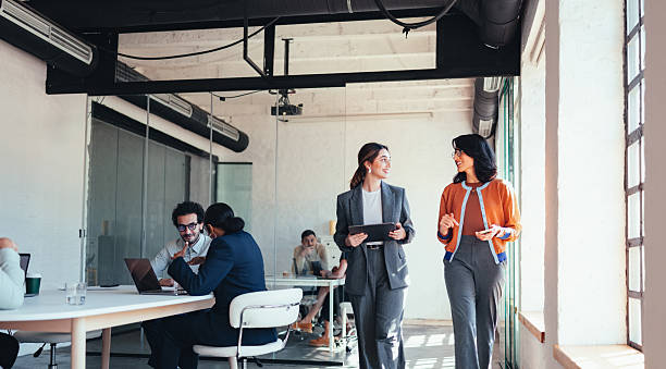 istock Two Professional Women Walk and Discuss in Modern Office During Team Meeting 2244066241