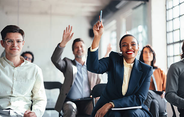istock Diverse Team Raising Hands in Office Meeting, Showing Engagement and Collaboration 2244066266
