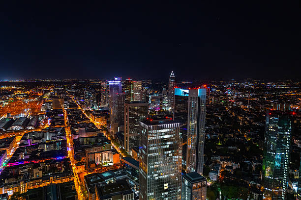 Frankfurt skyline at night, showcasing modern skyscrapers illuminated against the dark sky, highlighting the city's vibrant urban landscape and economic activity.