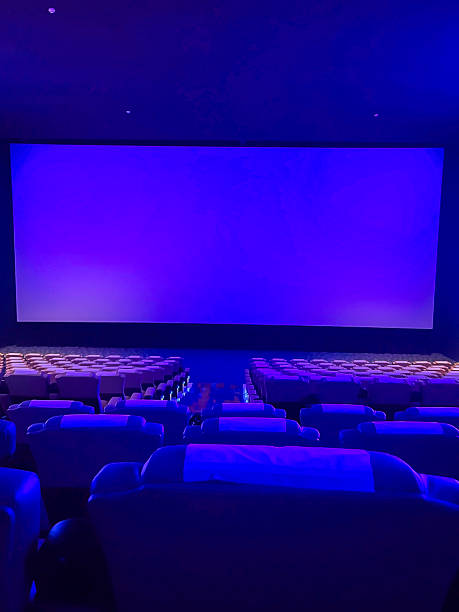 istock A pristine cinema hall with rows of plush, blue seats, a grand, illuminated screen, and subtle ambient lighting, creating an inviting atmosphere ready for the next audience. 2244070300