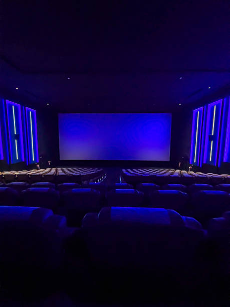 istock A pristine cinema hall with rows of plush, blue seats, a grand, illuminated screen, and subtle ambient lighting, creating an inviting atmosphere ready for the next audience. 2244070301
