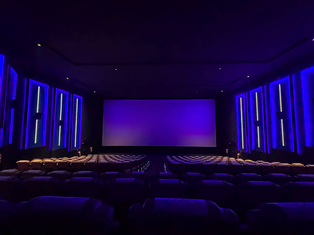 istock A pristine cinema hall with rows of plush, blue seats, a grand, illuminated screen, and subtle ambient lighting, creating an inviting atmosphere ready for the next audience. 2244070303