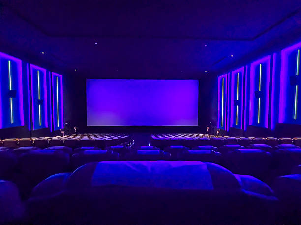 istock A pristine cinema hall with rows of plush, blue seats, a grand, illuminated screen, and subtle ambient lighting, creating an inviting atmosphere ready for the next audience. 2244070306