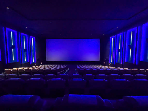 istock A pristine cinema hall with rows of plush, blue seats, a grand, illuminated screen, and subtle ambient lighting, creating an inviting atmosphere ready for the next audience. 2244070309