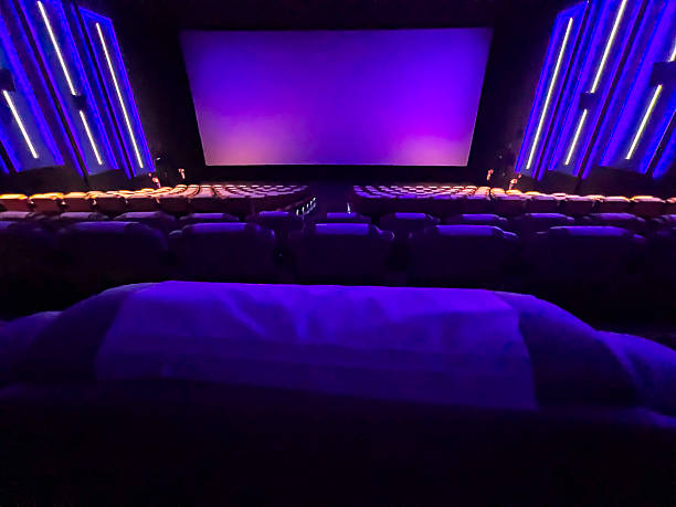 istock A pristine cinema hall with rows of plush, blue seats, a grand, illuminated screen, and subtle ambient lighting, creating an inviting atmosphere ready for the next audience. 2244070316