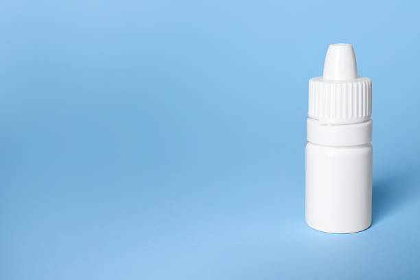 istock Bottle of medical drops on light blue background, space for text 2244072801