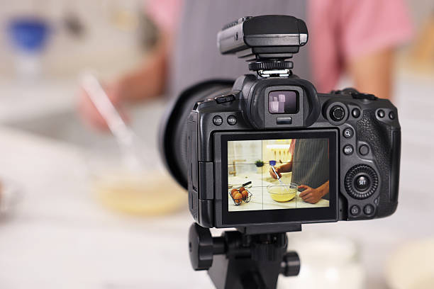 istock Food blogger cooking while recording video in kitchen, focus on camera 2244076437
