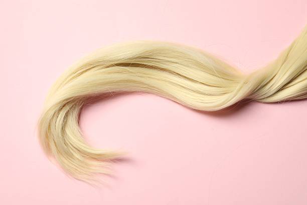istock Blonde hair strand on pink background, top view 2244077549