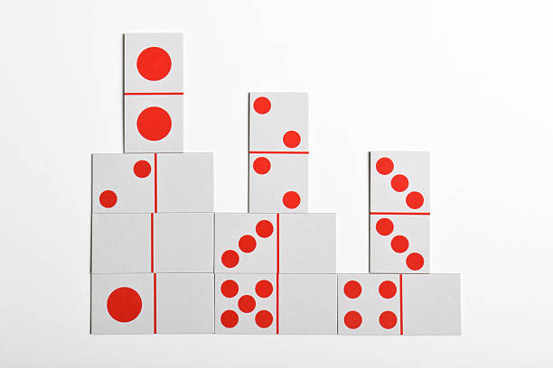 Domino effect ready to begin. Acrylic pieces in a row. Isolated on red background.
