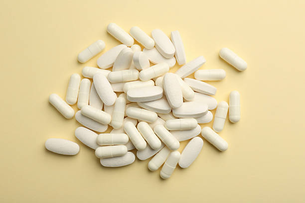 istock Vitamin pills on pale yellow background, flat lay 2244083375