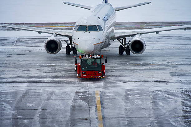 Denver, Colorado, USA - February 15, 2025: A United Express Embraer E175LR passenger aircraft at Denver International Airport during a winter snowstorm.