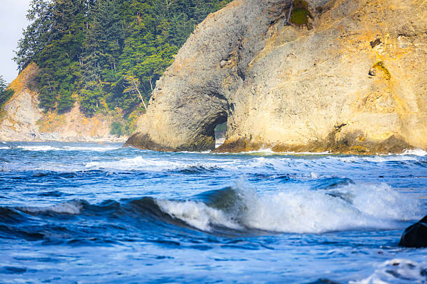 Famous Hole-in-the-Wall rock formation, an iconic arch sculpted by waves on the Pacific Ocean shore in Olympic National Park, Washington.