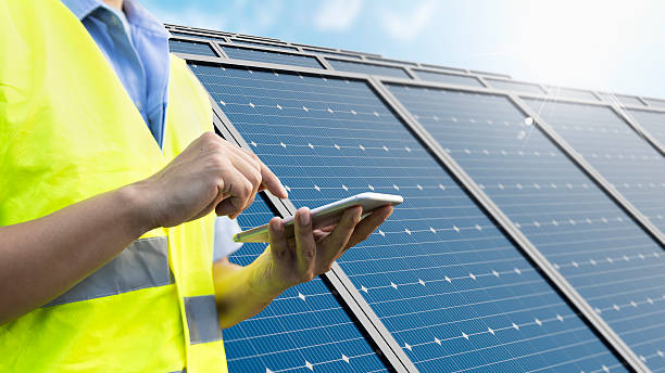 istock Engineer using mobile app for remote monitoring solar panels smart IoT technology 2244089117