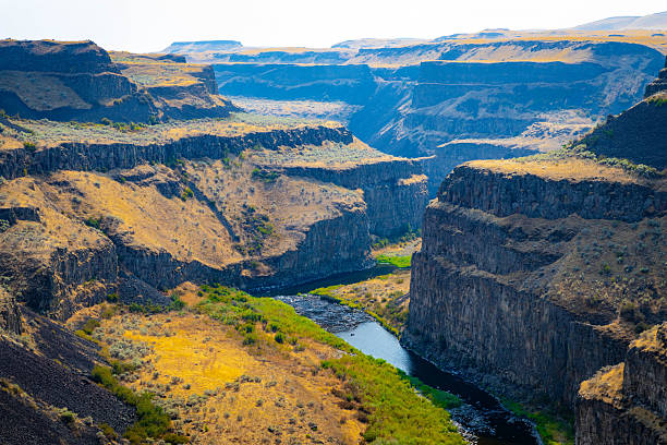 The famous Palouse Falls dramatically plunges into a gorge, illuminated by a vibrant, colorful sunset, creating a stunning scene at the Washington State Park.