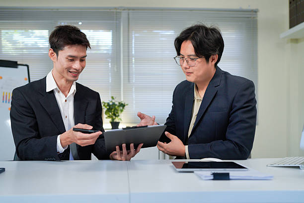 istock Teamwork makes everything easier. Shot of two young businessmen working together in an office. 2244095236