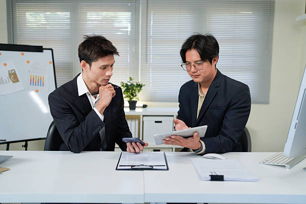 istock Teamwork makes everything easier. Shot of two young businessmen working together in an office. 2244095242