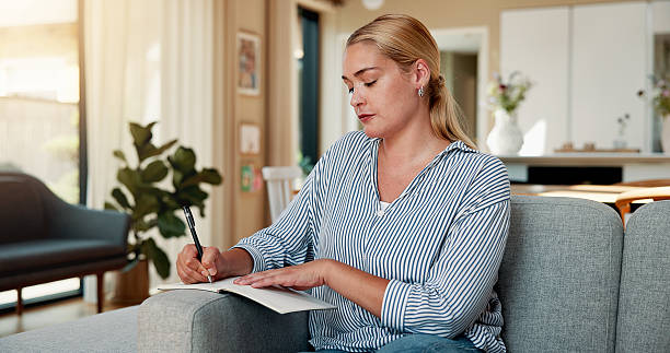 istock Woman, writing and relax on sofa with journal for planning goals, creative idea or process emotions. Daily reflection, notes or person in home with diary for self improvement, inspiration or insight. 2244096075