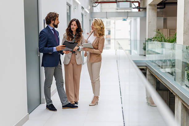 istock Business people discussing project in modern office hallway 2244096114