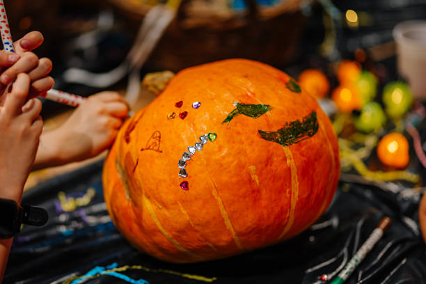 istock Colorful pumpkin decorated with stickers and drawings, surrounded by crafting materials, showcasing a creative and festive atmosphere for seasonal celebrations and artistic expression 2244096986