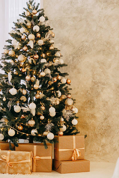 istock Christmas tree decorated with gold and white ornaments, presents underneath for Holiday celebration, festive interior design concept. 2244100332