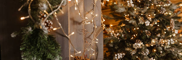 istock Christmas string light garland with glowing bulbs draped on a wooden pillar. Warm holiday decoration for festive interior. 2244100338
