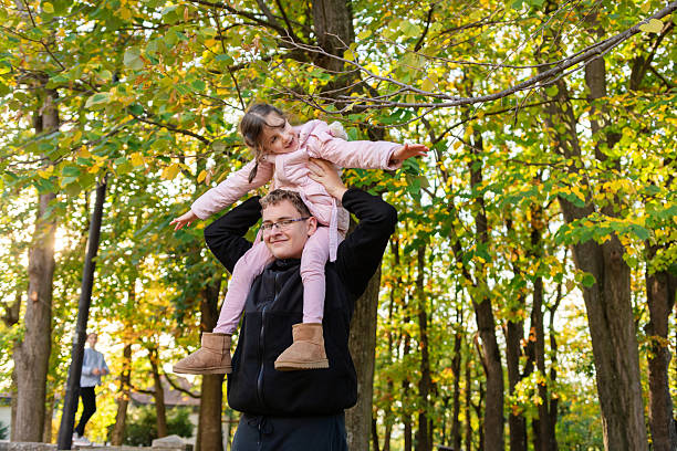 istock Boy carrying his little sister on shoulders in park 2244100792