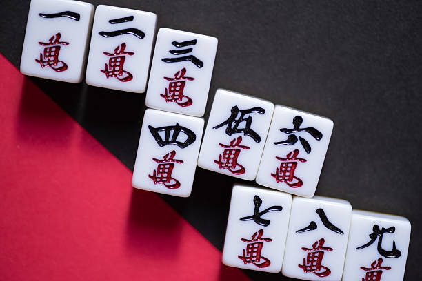 istock Mahjong tiles lined up on a red and black background 2244100916