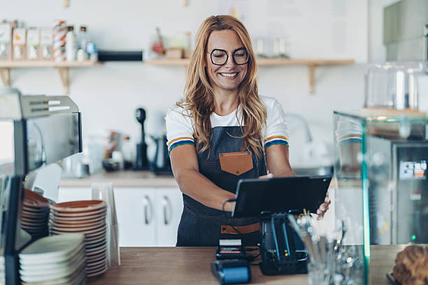 istock Smiling young barista using digital tablet in cafeteria 2244101888