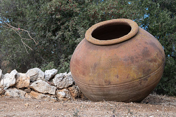 istock An ancient clay pot rests beside a stone wall in a tranquil countryside setting 2244101966