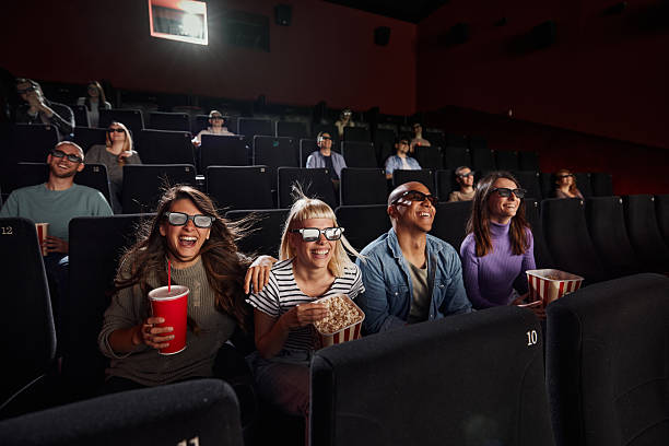 Large group of cheerful people with 3D eyeglasses watching a movie in cinema.