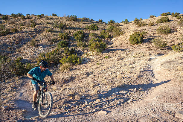 istock Mountain biker rides trail in desert 2244102606