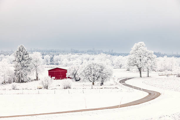Red barn in a wintry countryside by a curvy road