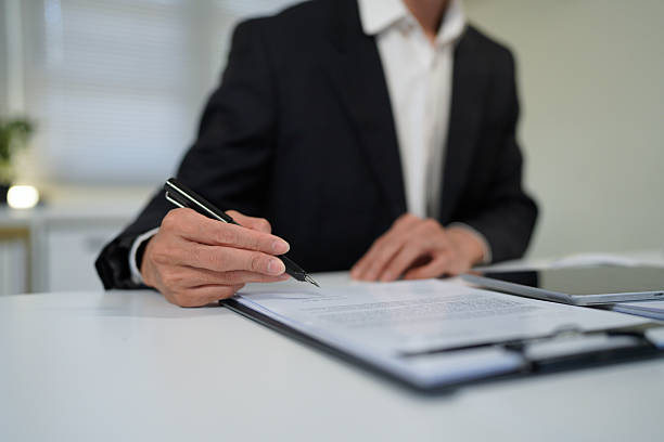 istock young man in suit writing business papers at desk in modern working office. copy space 2244102917