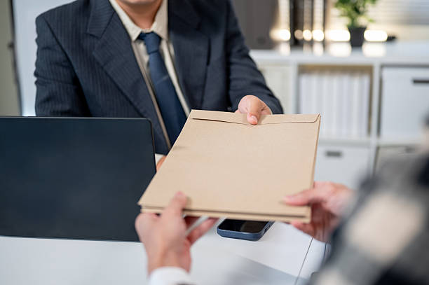 istock Close up of a man's hand receiving document envelope from a boss at working table in company office. 2244106276