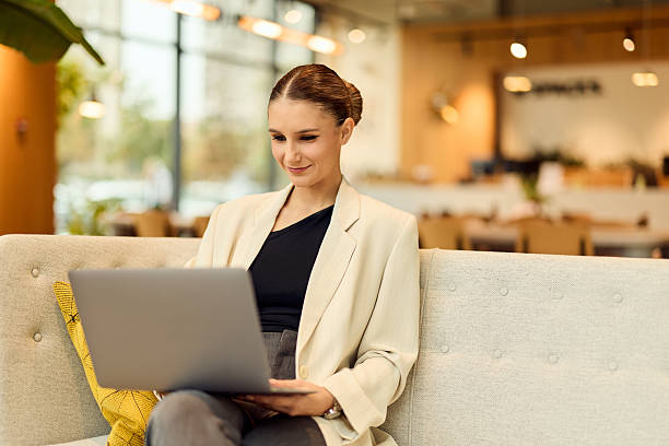 istock Professional Woman Using Laptop in Modern Office Lounge for Flexible Work 2244112903