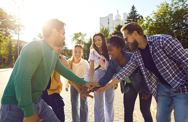 istock Team of happy young multiethnic friends stack their hands while having fun in the city 2244114238