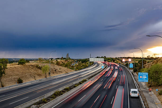 istock Highway traffic with light trails and dramatic storm sky 2244116625
