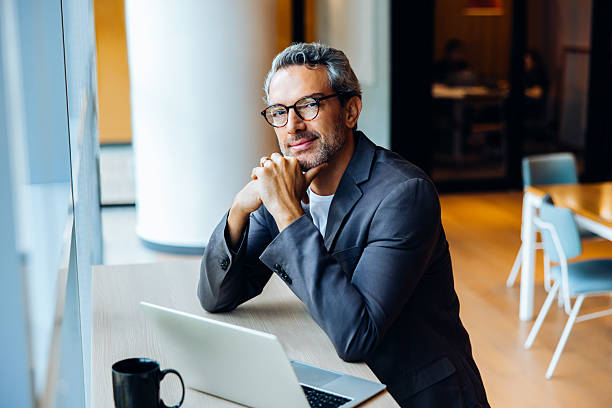 istock Professional man working on a laptop in a bright open office space 2244116639