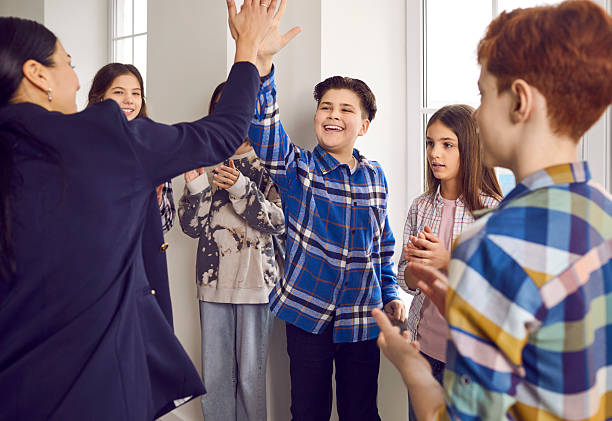 istock Happy school student giving high five to his teacher 2244116697