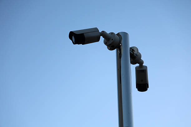 istock Outdoor Security Cameras Mounted On A White Pole Against Clear Blue Sky For Surveillance 2244118166