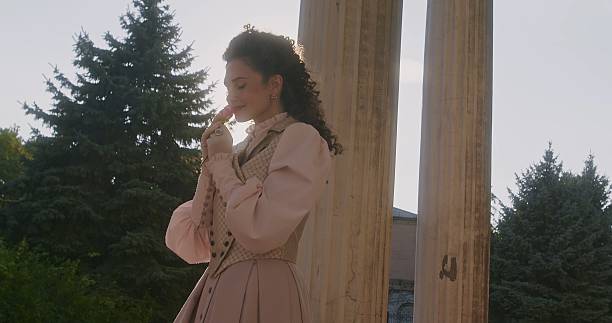 African descent young lady in brown fashion coat posing at park