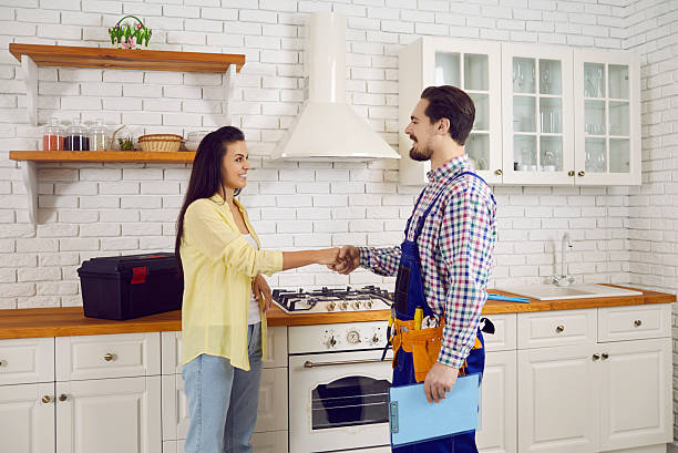 istock Male plumber handshake female client at visit 2244118291