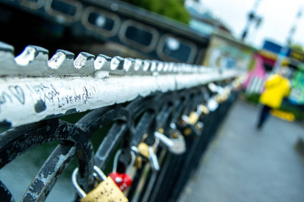 A sign of love or friendship with a padlock that has been locked onto a metal fenceline and left for eternity and others to see.