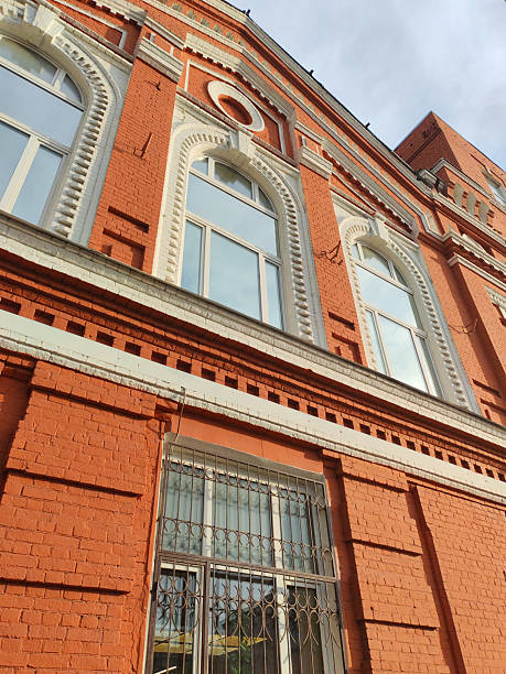 istock Metal security grilles adorn the windows of a red brick building, showcasing practical solutions for urban safety. The image reflects historic architecture integrated with modern security features. 2244123159